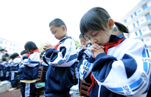 5月19日,湖南長沙曙光小學(xué)學(xué)生在升國旗前為四川地震災(zāi)區(qū)遇難同胞默哀。當日,湖南長沙數(shù)十所小學(xué)聯(lián)動舉行“1+1中華強”愛心集結(jié)行動,為四川地震災(zāi)區(qū)的同齡人祈禱祝福,并捐贈書籍27000余本、文體用品16000余件。新華社記者 趙眾志 攝