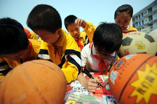 5月19日,湖南長沙曙光小學(xué)學(xué)生向四川地震災(zāi)區(qū)捐贈書籍和體育用品,并在橫幅上簽名。 新華社記者 趙眾志 攝