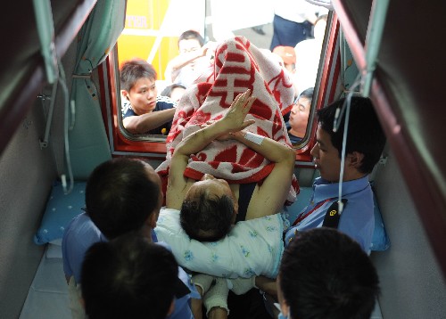 5月19日,醫(yī)療人員在綿陽火車站將一名地震傷員抬上火車。為使地震傷員得到及時治療、緩解災區(qū)醫(yī)療資源緊張局面,目前,有關部門正在轉移部分地震傷員到重慶等地的醫(yī)院接受治療。 新華社記者 楊世堯 攝