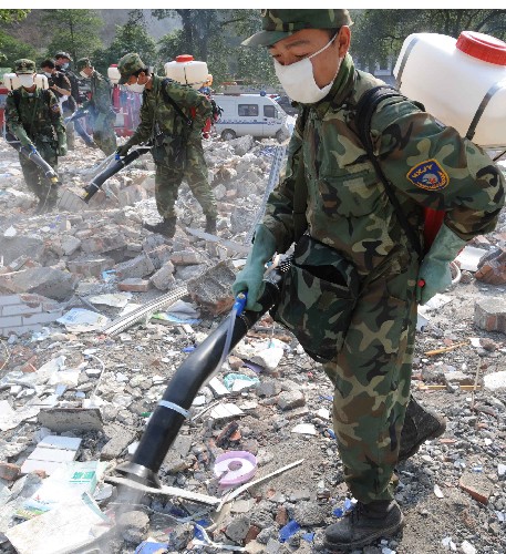 5月19日,成都軍區(qū)防化團(tuán)官兵在地震中變成一片廢墟的北川中學(xué)噴灑防疫藥劑。 新華社記者 陳樹根 攝