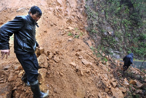 6月10日,一名當?shù)卮迕瘢ㄗ螅┳哌^塌方路段。安徽南部、江西及浙江交界地區(qū)連續(xù)兩天遭遇暴雨襲擊,給當?shù)氐慕煌?、生產(chǎn)和群眾生活帶來嚴重影響。皖南山區(qū)多處道路出現(xiàn)損毀,沿線出現(xiàn)山體滑坡和塌方。其中220省道休寧段塌方,導致安徽通往江西、浙江的交通中斷,車輛被阻。目前,公路部門正在抓緊搶修。新華社記者 王雷 攝