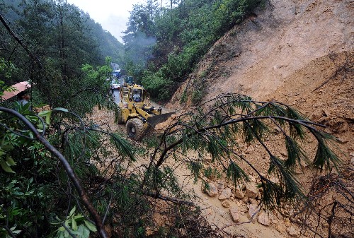 6月10日,黃山市公路部門組織人員和機械搶修公路。安徽南部、江西及浙江交界地區(qū)連續(xù)兩天遭遇暴雨襲擊,給當?shù)氐慕煌ā⑸a(chǎn)和群眾生活帶來嚴重影響。皖南山區(qū)多處道路出現(xiàn)損毀,沿線出現(xiàn)山體滑坡和塌方。其中220省道休寧段塌方,導致安徽通往江西、浙江的交通中斷,車輛被阻。目前,公路部門正在抓緊搶修。新華社記者 王雷 攝