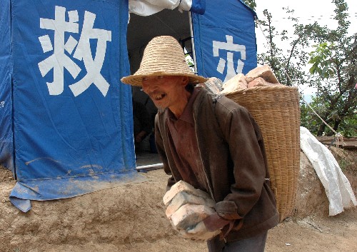 隴南市武都區(qū)馬街鎮(zhèn)姜家山村村民在搬運從廢墟中清理出的磚頭(6月10日攝)。目前,甘肅隴南一些鄉(xiāng)鎮(zhèn)已經(jīng)公布了災(zāi)后住房建設(shè)規(guī)劃草圖,正在征詢百姓意見。受災(zāi)群眾從廢墟中清理出磚頭、椽子等建筑材料,為即將進行的災(zāi)后重建做準(zhǔn)備。新華社記者 宋常青 攝