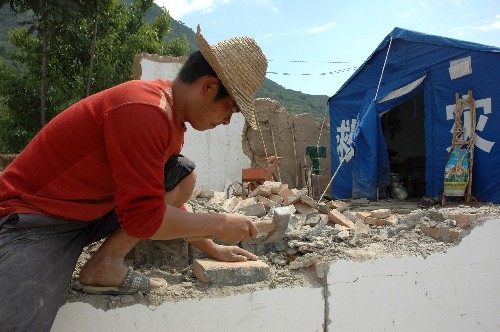 隴南市武都區(qū)馬街鎮(zhèn)姜家山村村民在從廢墟中清理磚頭(6月10日攝)。 新華社記者 宋常青 攝