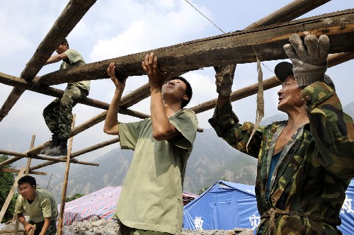 武警戰(zhàn)士在幫助映秀鎮(zhèn)漁子溪村村民董來齊(右一)搭建房屋(6月9日攝)。目前,參與救災(zāi)的部隊(duì)、武警官兵和當(dāng)?shù)馗刹恳呀?jīng)進(jìn)入汶川、茂縣和理縣三個重災(zāi)縣全部348個村莊,幫助各村開展災(zāi)后重建工作。新華社記者 李紫恒 攝