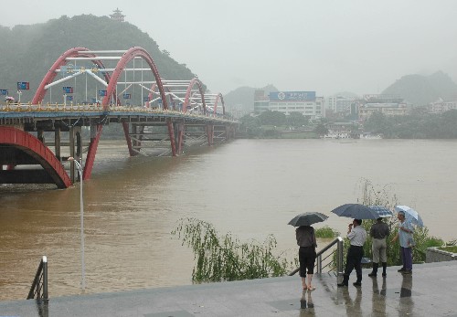6月13日,柳州市民在文惠橋附近觀看柳江水情。由于廣西柳州市區(qū)和柳江上游普降暴雨,截至13日15時15分,柳江水位已暴漲至85.85米,超過警戒水位3.35米。新華社發(fā)