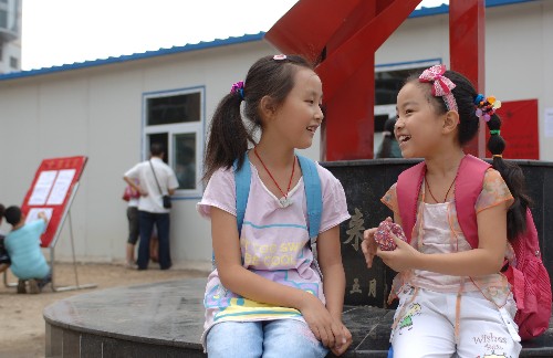 9月1日,在漢中市略陽(yáng)縣高臺(tái)小學(xué),前來(lái)報(bào)到的小學(xué)生在校門(mén)口聊天。新華社記者 丁海濤 攝