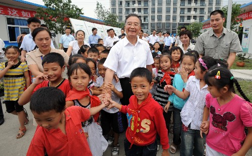 9月2日,溫家寶來到都江堰新建小學(xué)過渡板房學(xué)??赐⒆觽儠r(shí),孩子們簇?fù)碓诳偫砩磉叀V泄仓醒胝尉殖N?、國?wù)院總理、國務(wù)院抗震救災(zāi)總指揮部總指揮溫家寶近日來到四川地震災(zāi)區(qū),慰問受災(zāi)群眾,了解災(zāi)區(qū)群眾安置和恢復(fù)重建情況,對下一步工作做出部署。新華社記者 黃敬文 攝