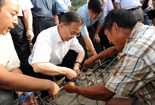 8月31日,溫家寶在青川縣棗樹村視察農(nóng)民永久性住房建設(shè)情況,與正在建房的村民一起綁鋼筋。新華社記者 黃敬文 攝