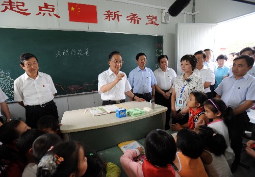 9月2日,溫家寶來到都江堰新建小學過渡板房學??赐⒆觽儠r,在黑板上寫下“美麗的花朵”五個粉筆字。新華社記者 黃敬文 攝
