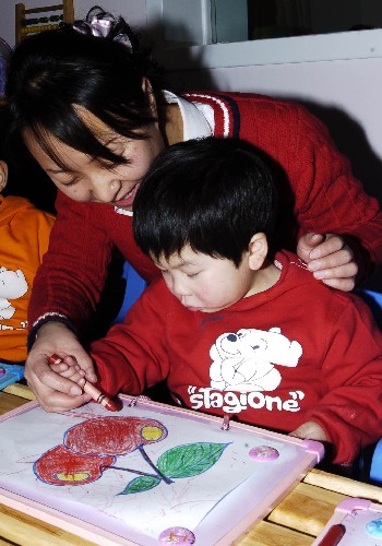 這是2007年12月15日,山西省大同市社會(huì)福利院兒童康復(fù)中心的康復(fù)師在教腦癱兒童畫畫。這個(gè)康復(fù)中心設(shè)有專門的康復(fù)訓(xùn)練場(chǎng)所,對(duì)孤殘兒童進(jìn)行早療早育治療,對(duì)術(shù)后的殘疾兒童及時(shí)開展功能性康復(fù)訓(xùn)練。新華社發(fā)