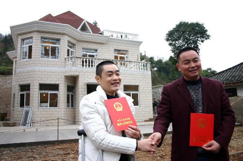 12月22日,都江堰市大觀鎮(zhèn)茶坪村村民王正良(右)和聯(lián)建者成都市民鄧小林(左)在展示分別領到的一本鮮紅的《集體土地使用證》。這是四川災區(qū)為農(nóng)房聯(lián)建辦理的首張集體建設用地使用權(quán)證,它標志著作為全國統(tǒng)籌城鄉(xiāng)綜合配套改革試驗區(qū)的成都市,在災后重建過程中又向城鄉(xiāng)土地“同證同權(quán)”邁出了堅實一步。王正良是成都市屬都江堰市大觀鎮(zhèn)茶坪村村民,他的房屋在地震中被震毀,因缺乏資金無力重建。今年6月,王正良與成都市民鄧小林達成協(xié)議,兩人聯(lián)合修建房屋。隨后,他們向有關部門提交了聯(lián)建協(xié)議、身份證、戶口簿及申請等相關資料辦理土地證。12月初,房屋竣工后,都江堰市國土資源局通過審批,分別為他們辦理了《集體土地使用證》。截至目前,都江堰市城鄉(xiāng)房屋重建已經(jīng)開工重建29521戶,其中社會資金開發(fā)重建開工達3420戶、48萬余平方米。新華社記者 劉海 攝