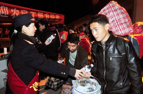 1月10日,宜昌火車站的工作人員為返鄉(xiāng)農民工送上免費礦泉水。當晚,湖北宜昌發(fā)出的首趟“農民工平安返鄉(xiāng)專列”順利從廣州火車站返程抵達宜昌,2000多名農民工順利返鄉(xiāng)。今年春節(jié)前,宜昌火車站還將發(fā)出4趟農民工專列赴廣州、深圳及北京接農民工回家。新華社發(fā)(蔡鈞庭 攝)