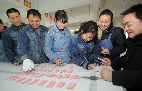 1月11日,在長興縣一家企業(yè)打工的外來務(wù)工人員正排隊領(lǐng)取單位為他們訂到的回鄉(xiāng)火車票。新華社記者 徐昱 攝