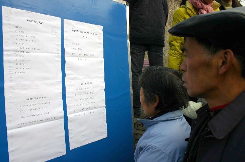 1月11日,都江堰市向峨鄉(xiāng)棋盤村村民正在查看分房工作的相關(guān)公示。新華社記者 劉海 攝