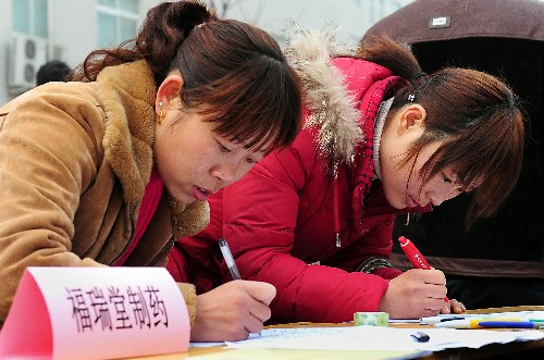 2月14日,兩位返鄉(xiāng)農(nóng)民工在填寫應聘報名表。新華社記者 王頌 攝