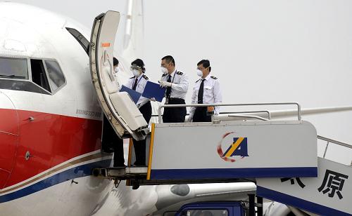 5月15日,太原機(jī)場出入境檢疫檢驗(yàn)局的工作人員準(zhǔn)備進(jìn)入機(jī)艙為入境航班旅客進(jìn)行測溫。新華社記者 燕雁 攝