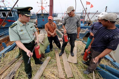 7月26日,青島營海邊防派出所民警李競在為漁民講解滅火器的正確使用,由于漁船都是連靠停泊,一旦發(fā)生火災(zāi)將“火燒連營”,后果不堪設(shè)想。近日,青島公安邊防支隊(duì)開展了為期一個月的夏季漁港治安、消防專項(xiàng)檢查,及時(shí)化解漁民糾紛、消除火災(zāi)隱患、加強(qiáng)對流動人員的宣傳和管理。眼下正是黃渤海伏季休漁期,也是沿岸漁港火災(zāi)、盜搶、賭博、治安事件傳統(tǒng)高發(fā)期。新華社記者 李紫恒 攝