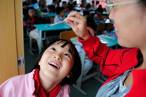 8月30日,在合肥市屯溪路小學(xué),老師為一名小學(xué)生測(cè)體溫。近日,安徽省合肥市中小學(xué)新學(xué)期學(xué)生陸續(xù)返校,一些學(xué)校對(duì)學(xué)生入校進(jìn)行體溫檢測(cè)。根據(jù)教育部、衛(wèi)生部要求,安徽省各學(xué)校將在開學(xué)后做好甲型H1N1流感疫情的監(jiān)測(cè)和防控工作。新華社發(fā)(張洪金 攝)