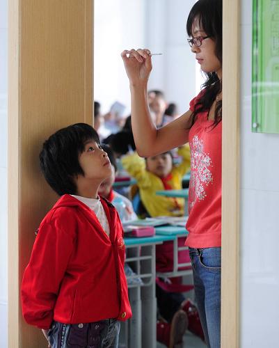 8月30日,在合肥市屯溪路小學(xué),老師為一名小學(xué)生測(cè)體溫。新華社發(fā)(張洪金 攝)