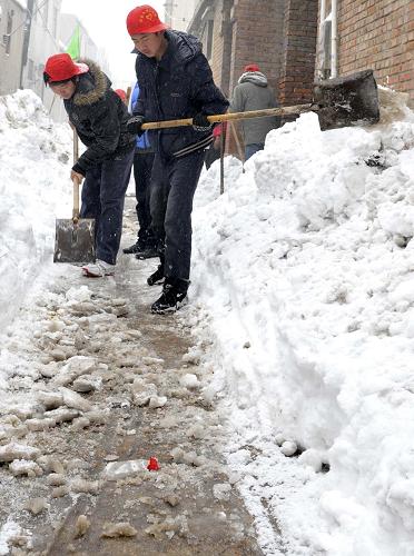 11月14日,邢臺市文明志愿者在小巷里清除積雪。新華社發(fā)(陳雷 攝)