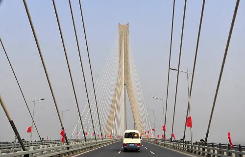12月26日,車(chē)輛從武漢天興洲長(zhǎng)江大橋上駛過(guò)。當(dāng)日,在中國(guó)橋梁建設(shè)史上具有里程碑意義的武漢天興洲長(zhǎng)江大橋正式通車(chē),從而結(jié)束了“萬(wàn)里長(zhǎng)江第一橋”武漢長(zhǎng)江大橋獨(dú)立支撐武漢鐵路過(guò)江半個(gè)多世紀(jì)的歷史。該橋的建成,為中國(guó)京廣、滬蓉南北兩條鐵路干線(xiàn)提供了新的快速過(guò)江通道,將大大緩解鐵路過(guò)江能力緊張狀況。天興洲長(zhǎng)江大橋是鐵道部和湖北省及武漢市合作興建的國(guó)家“十五”重點(diǎn)工程,也是武(漢)廣(州)高鐵客運(yùn)專(zhuān)線(xiàn)的重要控制性工程,分公路和鐵路上下兩層,耗資達(dá)110.6億元,全長(zhǎng)4657米,是我國(guó)首座四線(xiàn)公路鐵路兩用斜拉索橋,創(chuàng)下跨度、荷載、速度、寬度四項(xiàng)世界第一。新華社記者 郝同前 攝