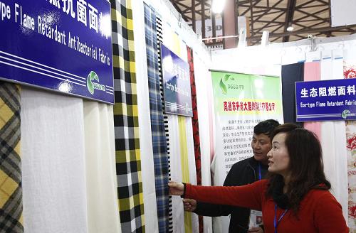 3月1日,兩位觀眾在展會(huì)上參觀一家企業(yè)推出的新型布料。新華社記者 裴鑫 攝