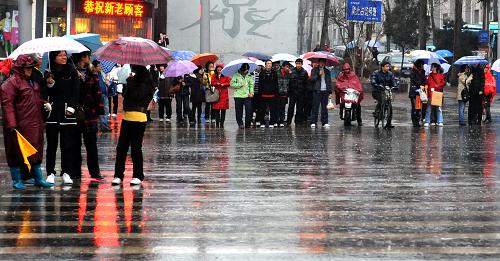 3月14日,濟(jì)南市民冒雨出行。 當(dāng)日,受冷空氣影響,濟(jì)南市降下春雨。新華社發(fā)