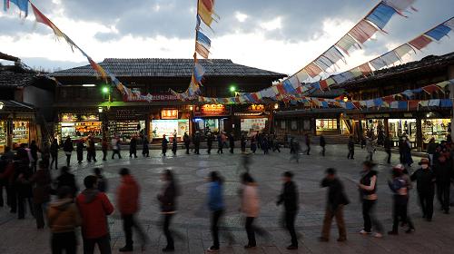 這是外地游客和當(dāng)?shù)厝罕娫谠颇鲜〉蠎c藏族自治州香格里拉縣獨克宗古城內(nèi)一起跳鍋莊舞(3月14日攝)。新華社記者 藺以光 攝