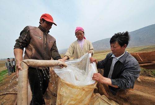 3月24日,熱水鎮(zhèn)營(yíng)溝村上營(yíng)第三小組組長(zhǎng)張薦(左一)在取水點(diǎn)幫村民裝水。新華社記者 何俊昌 攝