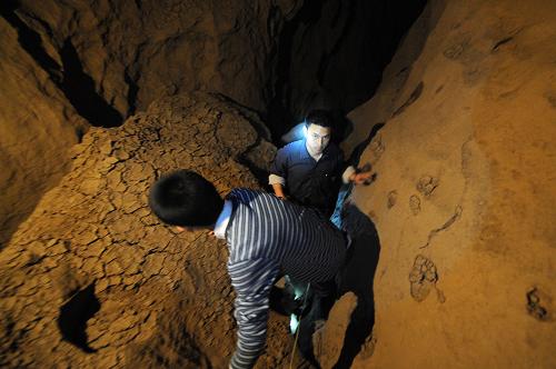 3月31日,南丹縣八圩瑤族鄉(xiāng)村民在立坳村九圩屯一百多米深的山洞里查看水源。新華社記者 黃孝邦 攝