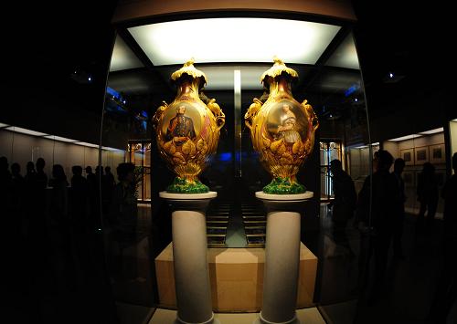 游客在觀看1851年倫敦世博會展出的繪有維多利亞女王肖像及水晶宮內(nèi)景的帶蓋花瓶(右)和繪有阿爾伯特親王肖像及水晶宮內(nèi)景的帶蓋花瓶(4月25日攝)。新華社記者 程敏 攝