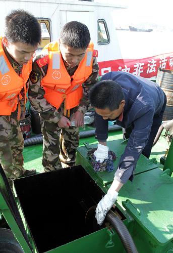 12月27日,邊防民警在一艘可疑油船上進(jìn)行油品抽樣檢查。新華社記者 徐昱 攝