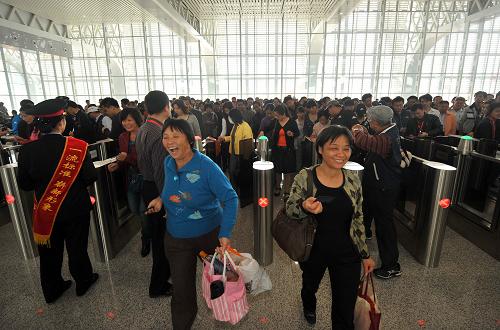 12月30日, 海南東環(huán)高速鐵路開(kāi)通后的首批乘客正在通過(guò)檢票口。新華社記者 郭程 攝