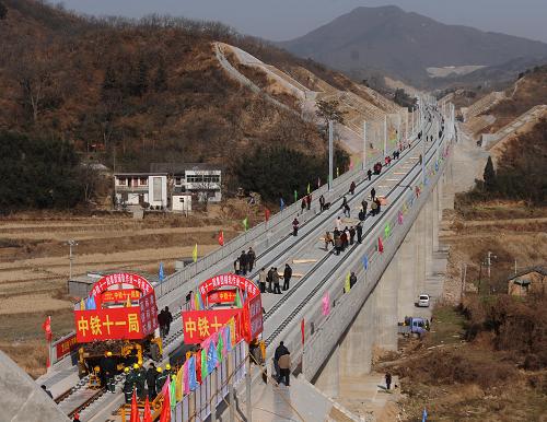 12月30日,中鐵十一局的鋪軌車正在鋪設(shè)石武高鐵湖北段最后一對長軌。新華社記者 程敏 攝