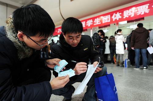 1月4日,在杭州火車站,浙江工業(yè)大學(xué)的輔導(dǎo)員核對為該校學(xué)生購買的100多張火車票。新華社發(fā)