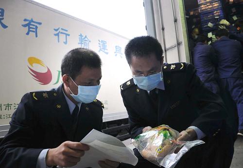 1月31日,文錦渡口岸的檢驗(yàn)檢疫工作人員在檢查運(yùn)港凍雞產(chǎn)品。新華社記者 王浩明 攝
