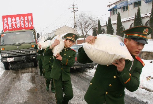 2月2日,武警安徽總隊官兵為雪災(zāi)重災(zāi)區(qū)合肥市肥西縣上派鎮(zhèn)四十埠社區(qū)群眾送年貨。當(dāng)日,武警安徽總隊派出4輛滿載米、面、油、菜和衣被的大卡車,來到合肥市肥西縣上派鎮(zhèn)四十埠社區(qū),慰問受災(zāi)群眾。 新華社發(fā)(廖福安 攝)