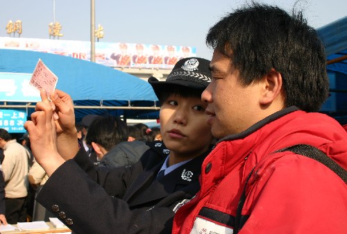 2月14日,鐵路警察正在為外出務(wù)工人員介紹假火車票識別方法。