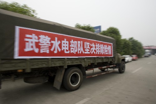 5月25日,載著武警水電部隊官兵的車輛駛往唐家山堰塞湖方向。 當(dāng)日,約150名武警水電部隊官兵從綿陽機場出發(fā)前往北川地區(qū),準(zhǔn)備徒步前往唐家山堰塞湖大壩。 新華社記者朱煒攝