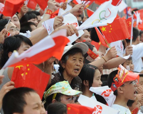 5月25日,群眾沿途迎接奧運(yùn)圣火。當(dāng)日,北京奧運(yùn)會(huì)圣火在江蘇南通傳遞。 新華社記者孫參攝