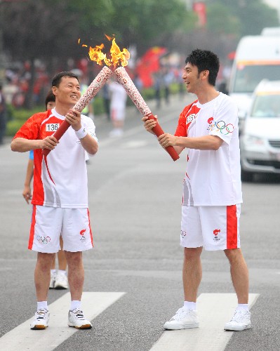 7月4日,火炬手林依輪(右)與下一棒火炬手張景亭交接。 新華社記者 邢廣利 攝