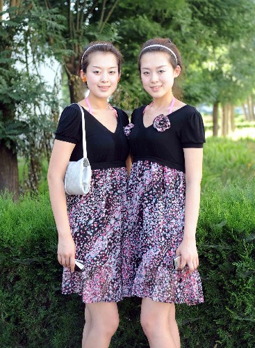 7月12日,一起成為奧運會頒獎儀式專業(yè)志愿者的雙胞胎姐妹李曉曄(左)、李子曄在校園合影。 新華社記者 羅曉光 攝