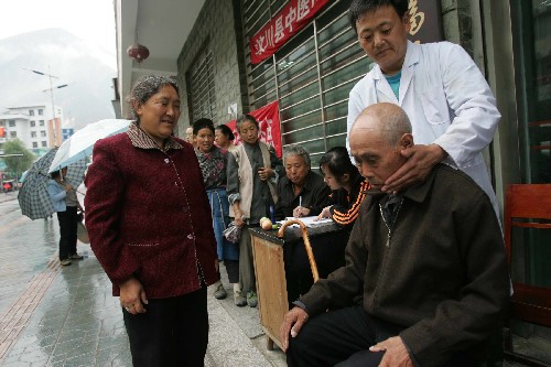 7月17日,來(lái)自山東萊蕪的醫(yī)師沙明星在汶川縣城街頭為居民治病。地震后沙明星自費(fèi)來(lái)到汶川,已經(jīng)免費(fèi)為當(dāng)?shù)鼐用裰尾∫粋€(gè)多月。目前,汶川抗震救災(zāi)工作正在有序進(jìn)行中。“5·12”汶川大地震兩個(gè)月后汶川縣城的自來(lái)水已經(jīng)正常供應(yīng),電力部分供應(yīng),通訊也恢復(fù)正常,雖然余震時(shí)有發(fā)生,但居民的生產(chǎn)生活在逐步恢復(fù)。 新華社記者 魯金博 攝