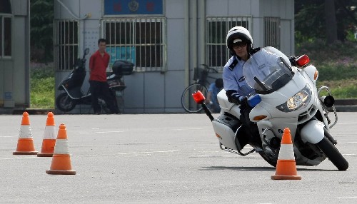 7月17日,上海交警總隊(duì)機(jī)動(dòng)支隊(duì)舉辦“迎奧運(yùn)、強(qiáng)技能、練精兵”業(yè)務(wù)技能比武競(jìng)賽,一名交警正騎著摩托車(chē)?yán)@樁。 新華社發(fā)