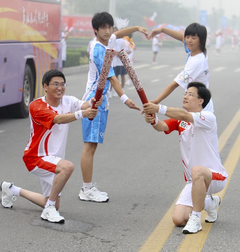 7月28日,火炬手邢建國(右)與下一棒火炬手康進(jìn)忠交接。 新華社記者 邢廣利 攝