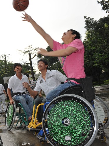 9月4日,幾位廣州市培英職業(yè)技術(shù)學(xué)校的殘疾學(xué)生在冒雨打籃球。廣州市培英職業(yè)技術(shù)學(xué)校是廣東省唯一的招收各類殘疾學(xué)生的中專學(xué)校,為參加北京殘奧會的中國代表團輸送了兩名選手。即將開幕的北京殘奧會極大的激發(fā)了廣州殘疾人的體育熱情。 新華社記者 壯錦 攝