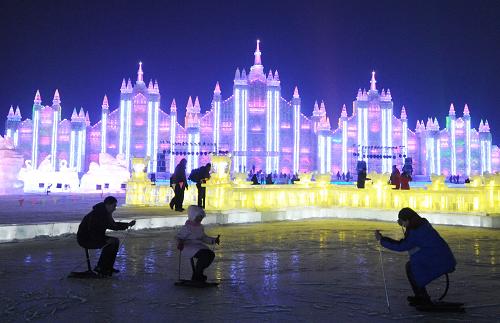 1月5日,游客在冰雪大世界一冰景前玩冰爬犁。 新華社記者 王建威 攝