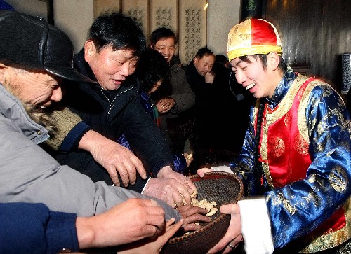 2月8日,“祝福”祭祀活動(dòng)后,表演者向游客“散福”。新華社發(fā)(袁云 攝)