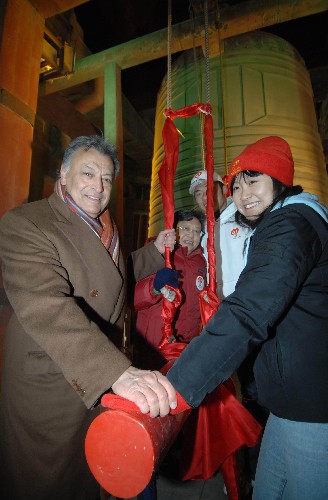 1月1日凌晨,國(guó)際著名指揮家祖賓·梅塔(左一)與嘉賓及志愿者代表在北京鐘樓上敲響報(bào)時(shí)銅鐘。1月1日凌晨,北京奧運(yùn)會(huì)志愿者“微笑圈”國(guó)際版發(fā)布儀式暨志愿者迎接2008慶典活動(dòng)在北京鐘鼓樓舉行,來(lái)自社會(huì)各界的近千人參加了活動(dòng),出席儀式的領(lǐng)導(dǎo)共同發(fā)布了奧運(yùn)志愿“微笑圈”國(guó)際版。1日零時(shí),鐘樓上被譽(yù)為“古鐘之最”、重達(dá)63噸的報(bào)時(shí)銅鐘被敲響,宣告新的一年到來(lái),同時(shí)把志愿者的微笑和祝福傳向四方。 新華社記者羅曉光攝